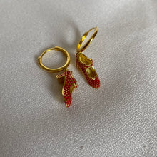 Load image into Gallery viewer, Pendientes de aro dorados con zapatos de flamenco en esmalte rojo
Pendientes de aro en acero inoxidable bañado en oro con charm en forma de zapato de flamenco rojo esmaltado. Diseño único y llamativo, ideal para los amantes del estilo flamenco y la joyería original.