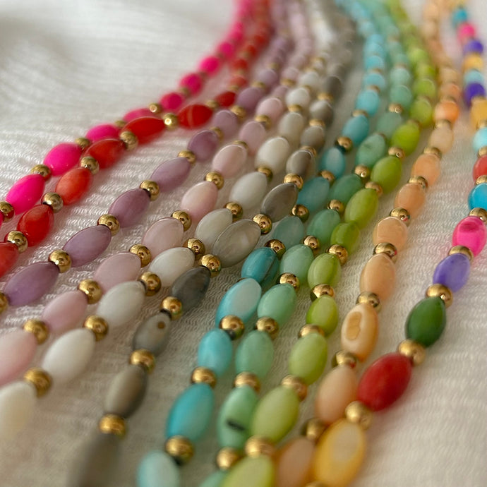 collares de cuentas ovaladas en varios colores del mar sobre fondo blanco, inspirados en elementos marinos y veraniegos.