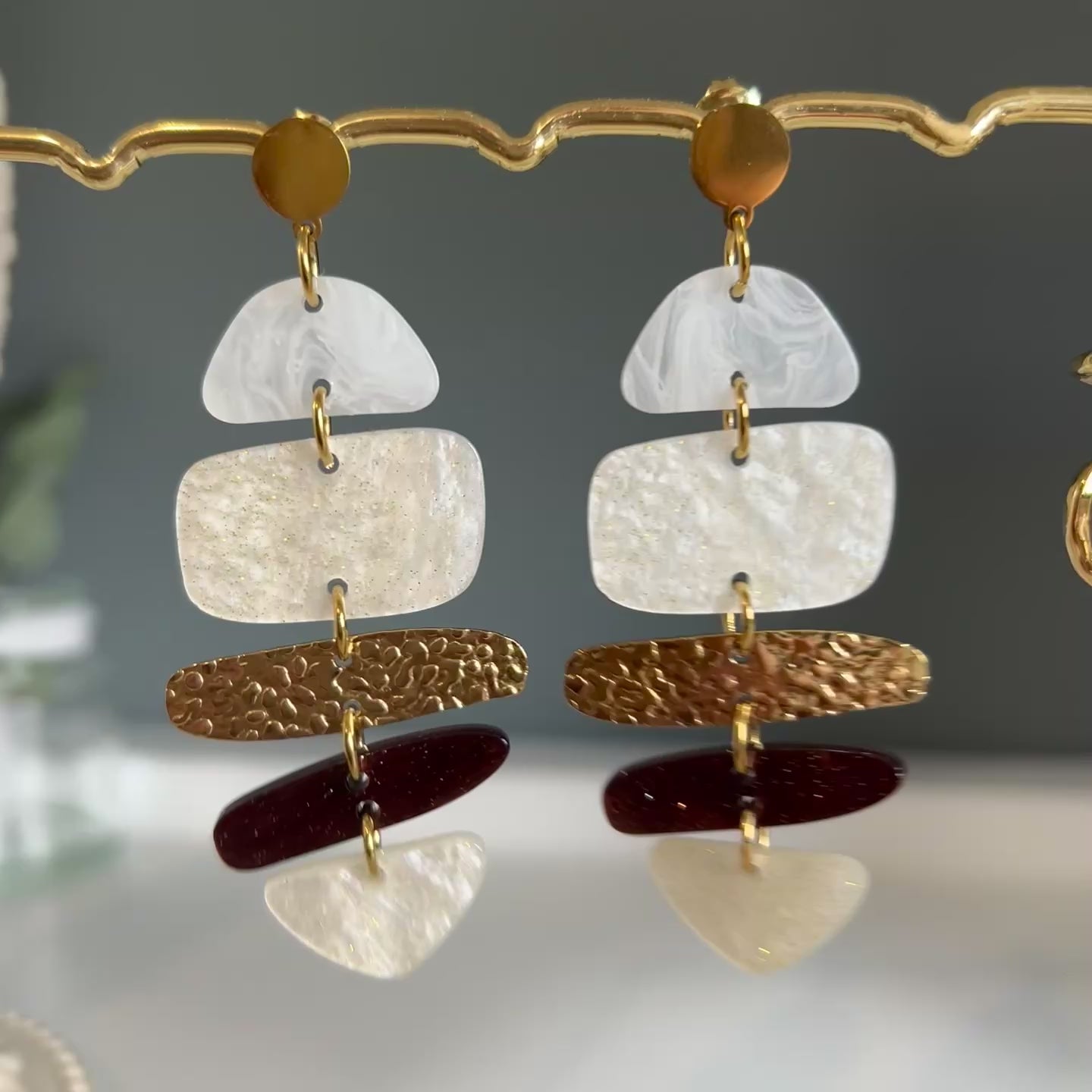 Pendientes colgantes con piezas de resina blanca, marrón y dorada combinadas con placas metálicas martilladas. Diseño moderno y elegante.
Título SEO: Pendientes colgantes de resina y metal dorado | Joyería artesanal
Descripción SEO: Descubre estos hermosos pendientes colgantes con piezas de resina blanca, marrón y dorada, combinadas con detalles metálicos martillados. Un accesorio perfecto para realzar tu estilo con un toque mo
